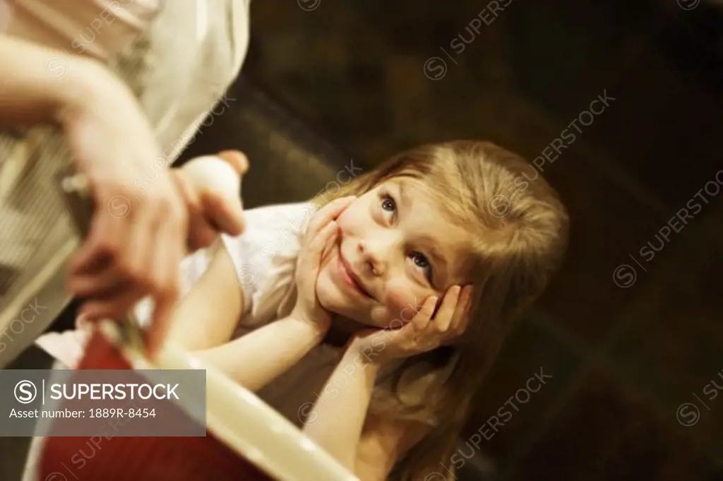 Young girl watching mother bake