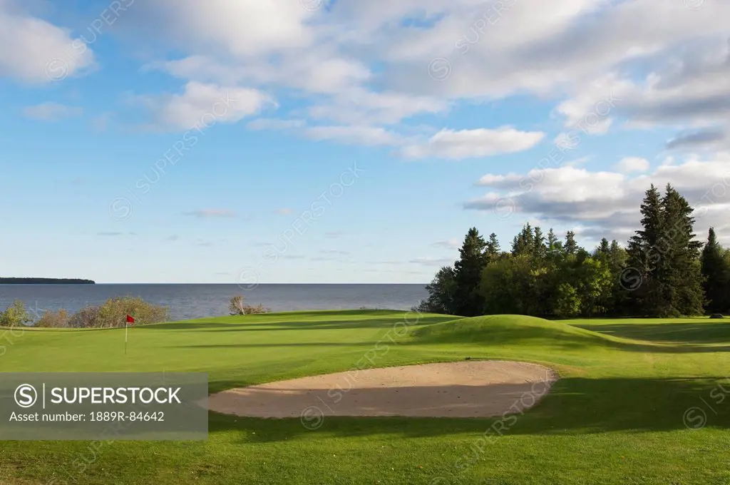 Golf course putting green and pin on lake, hecla island manitoba canada