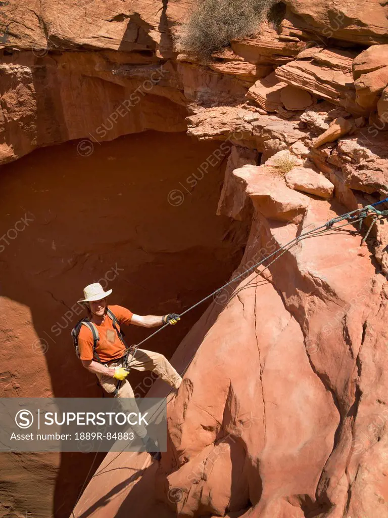 Man rappelling into a canyon, san rafael swell utah united states of america