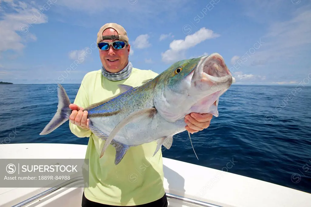 Man holds fresh caught jack fish, panama
