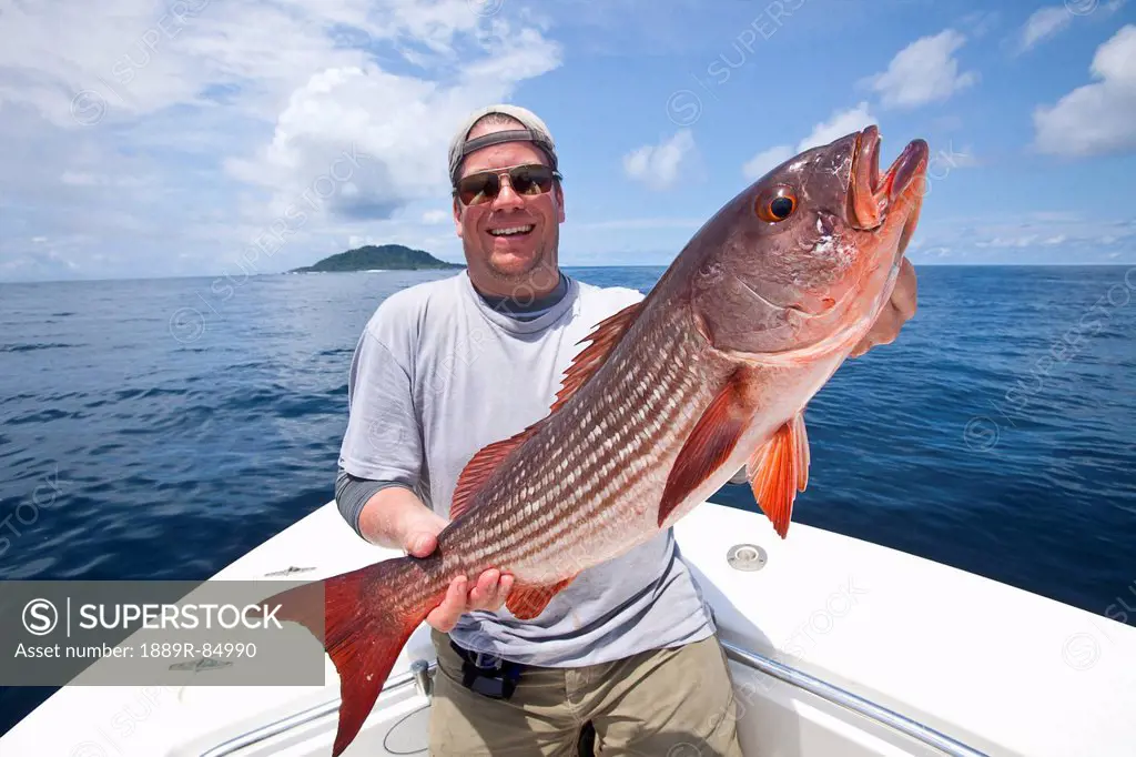 Man holds fresh caught mullet snapper, panama