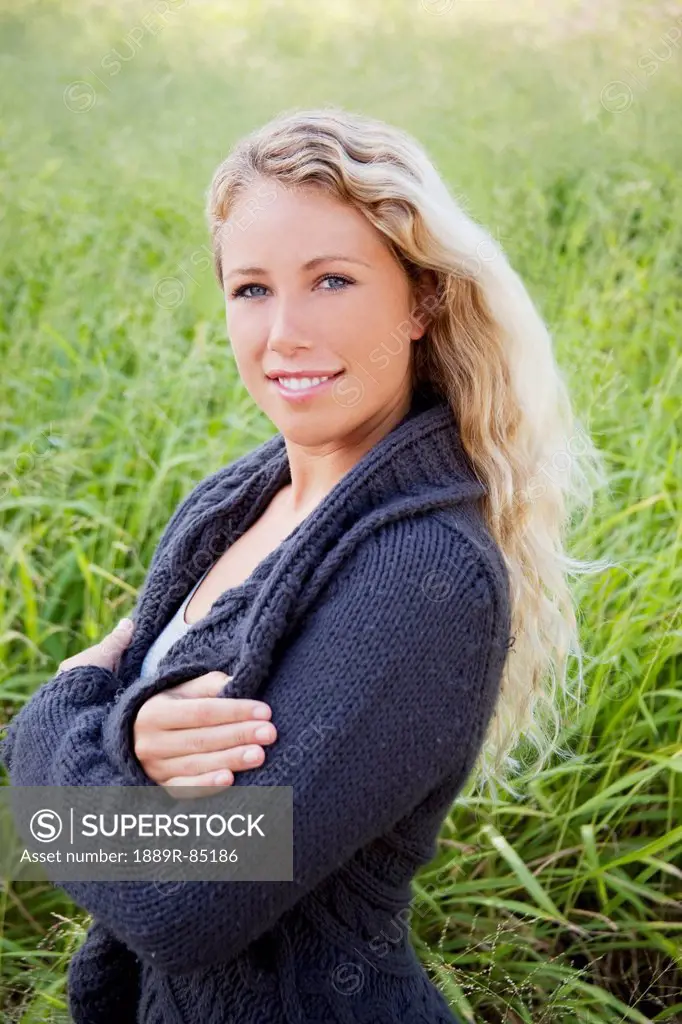 Portrait of a young woman standing in a grass field, hawaii united states of america