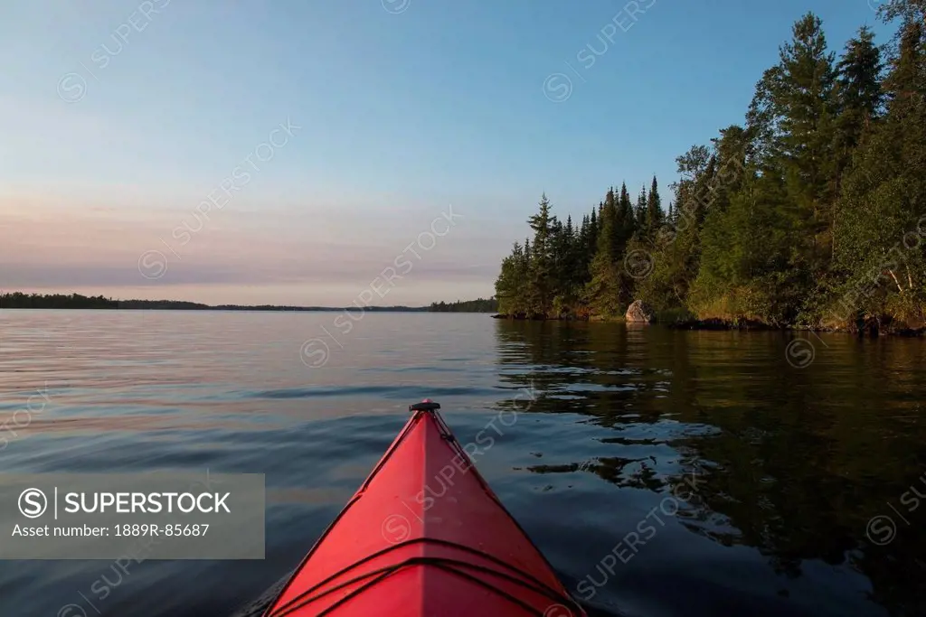 Bow Of A Red Canoe On A Tranquil Lake, Keewatin Ontario Canada
