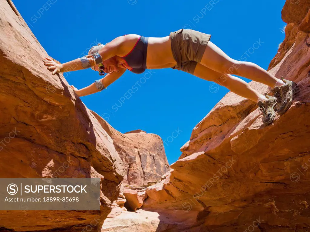 A Female Athlete Bridgiing A Utah Slot Canyon, Hanksville Utah United States Of America