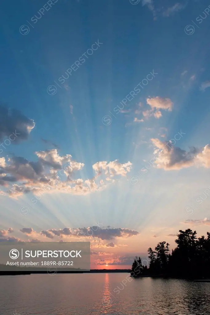 Sun Rays Through The Blue Sky With Cloud Over A Lake At Sunset, Ontario Canada