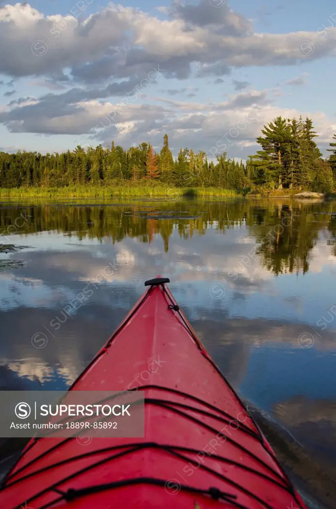 The Bow Of A Red Kayak In A Tranquil Lake, Lake Of The Woods Ontario Canada
