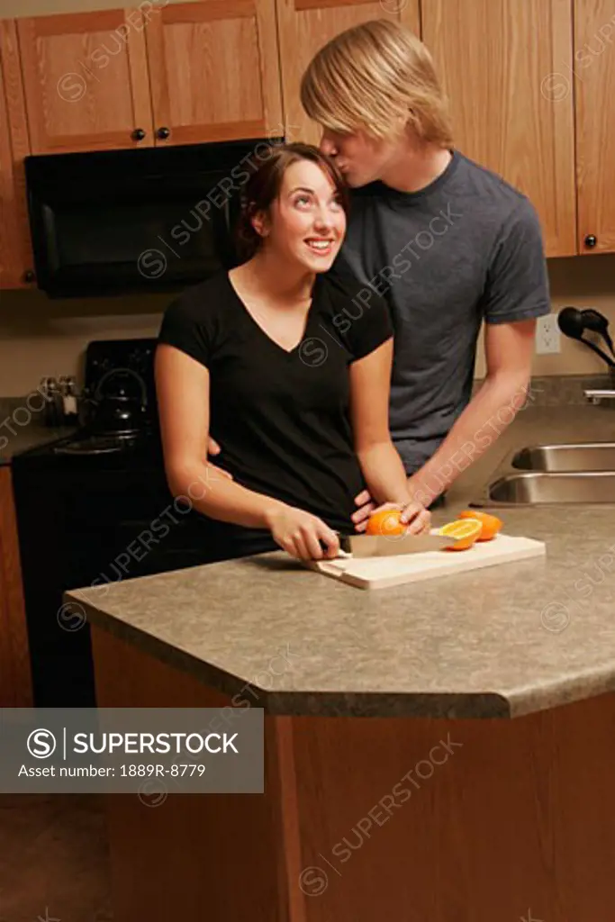 Man kissing woman in kitchen