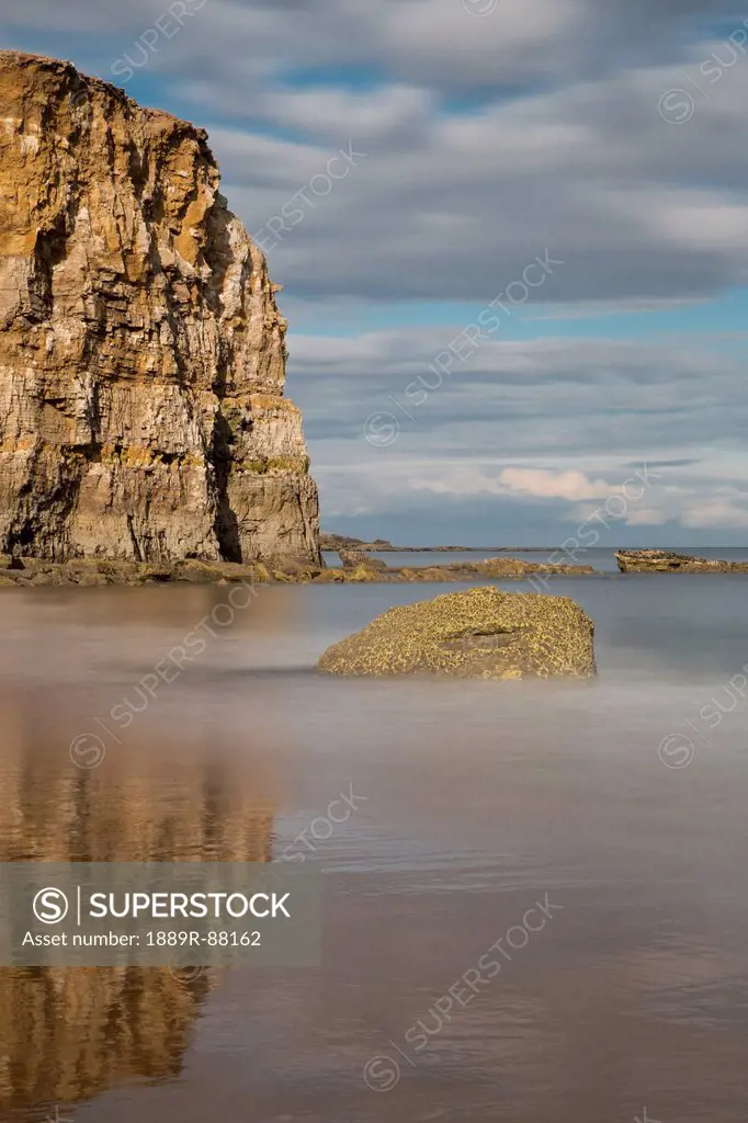 Large Rock Formation Reflected In The Shallow Water Along The Coast;South Shields Tyne And Wear England