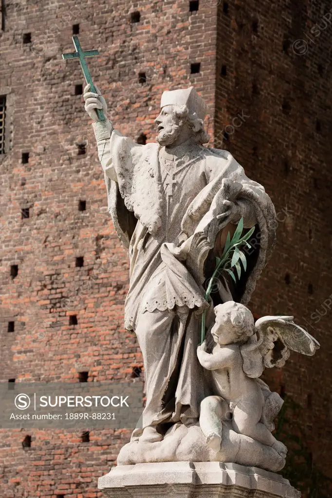 Statue Holding A Cross In Front Of A Brick Wall Of The Sforza Castle;Milano Lombardia Italy
