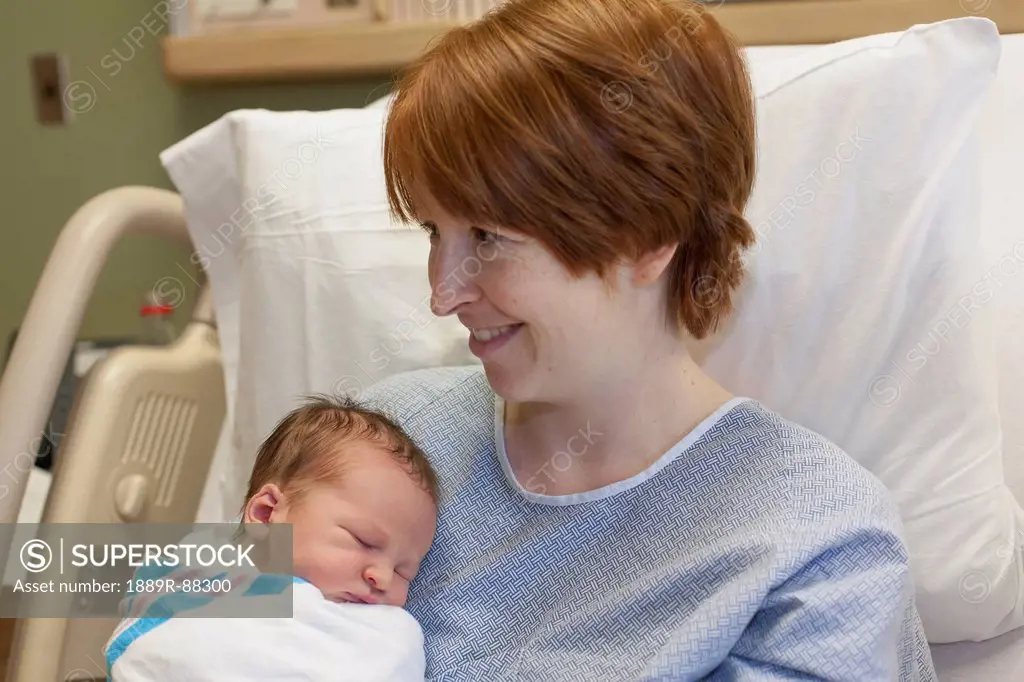 A mother holds her newborn baby in a hospital bed;Willimantic connecticut united states of america