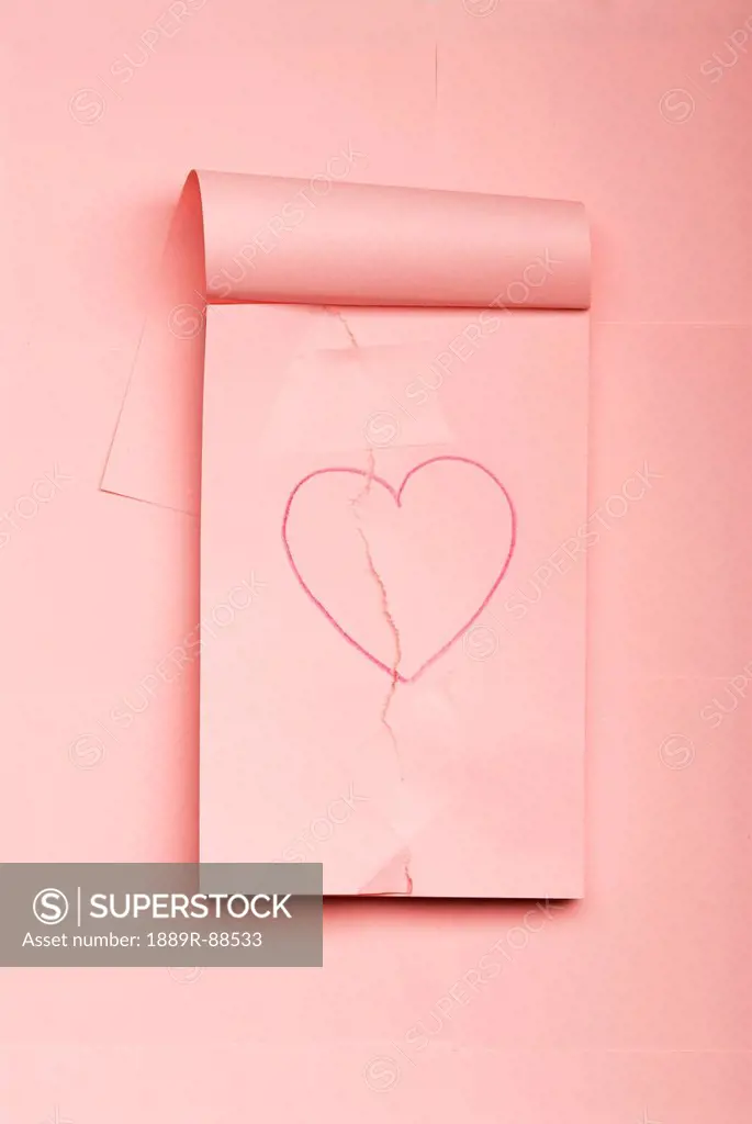Notepad with hand drawn heart ripped and mended with scotch tape