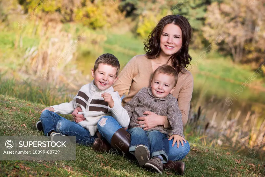 A mother with her two young sons in a park in autumn;St. albert alberta canada