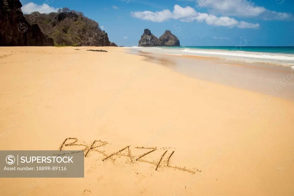 View of morro dos irmaos from praia do bode with brazil written in the sand;Fernando de noronha pernambuco brazil