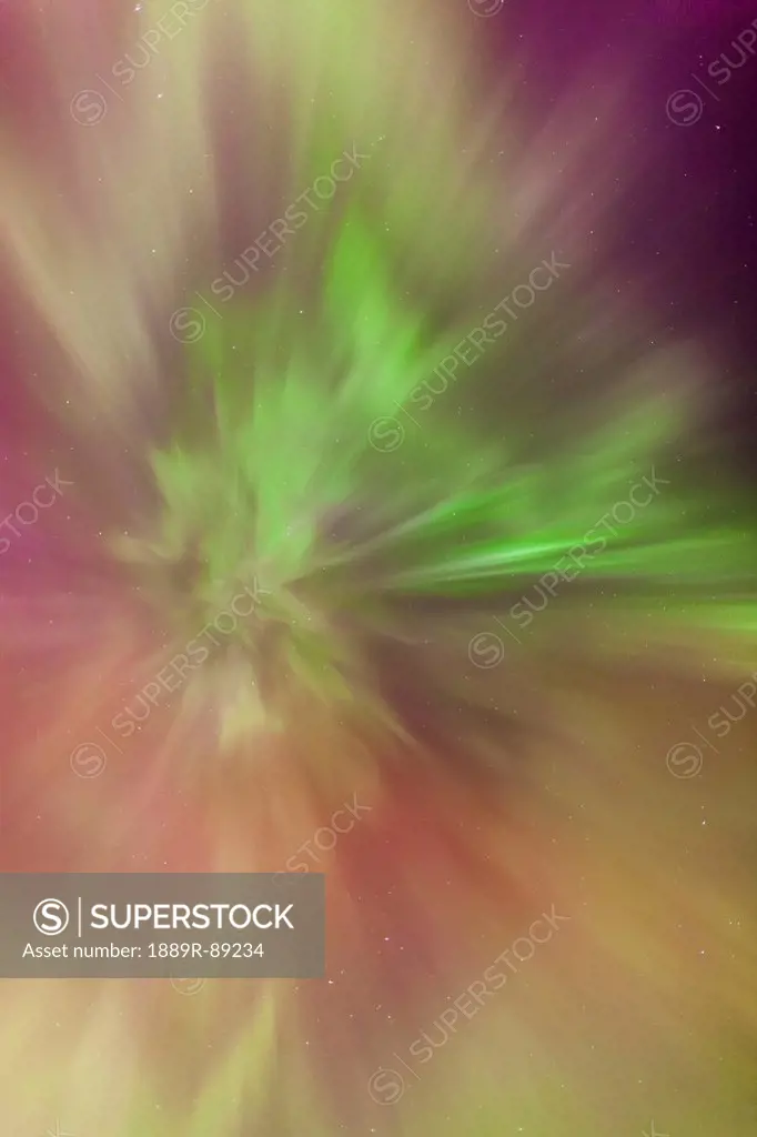 A green and orange northern lights corona in the sky above the tony knowles coastal trail in winter;Anchorage alaska united states of america