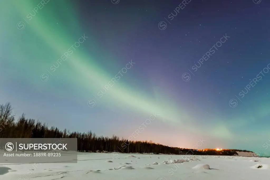 The northern lights in the sky above the tony knowles coastal trail and point woronzof in winter at nighttime;Anchorage alaska united states of americ...
