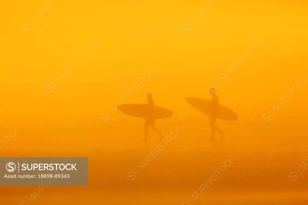 Surfers in the fog on long beach pacific rim national park;Vancouver island british columbia canada