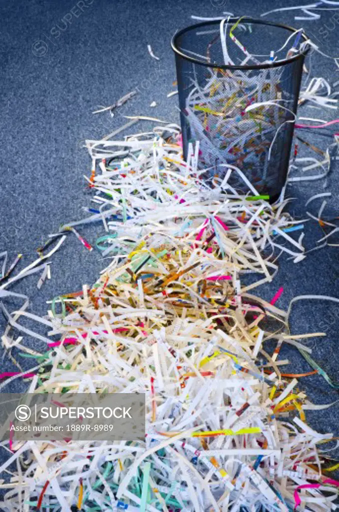 Pile of shredded paper leading to garbage can