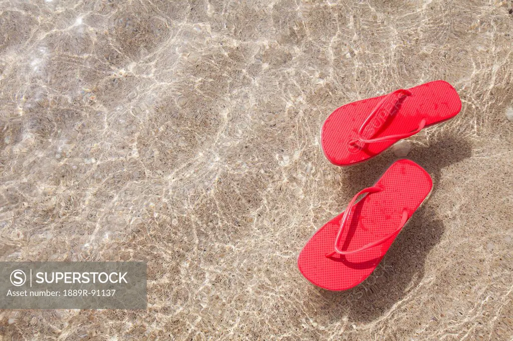 Red beach slippers floating in the ocean;Honolulu oahu hawaii united states of america