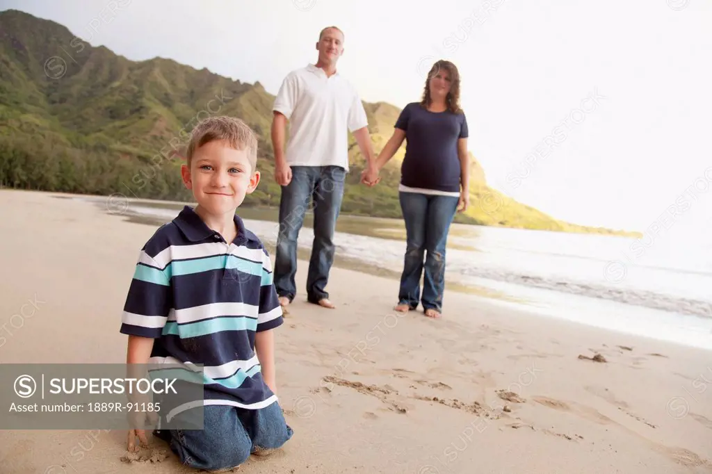 A family poses for a portrait on a beach;Oahu hawaii united states of america