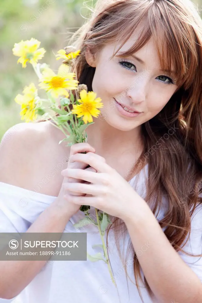 Portrait of a young woman holding a bouquet of yellow flowers;Honolulu oahu hawaii united states of america