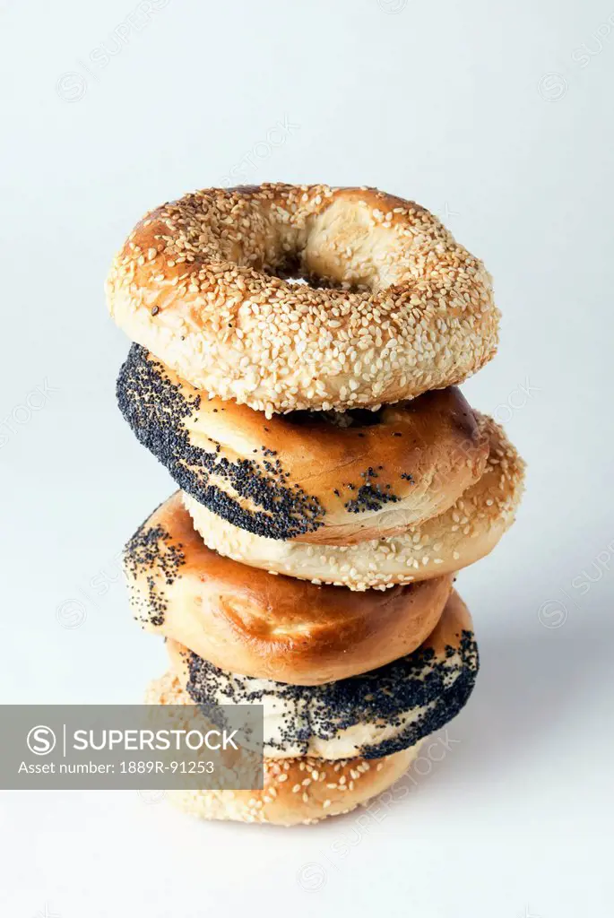 Poppy seed and sesame seed bagels on a white background