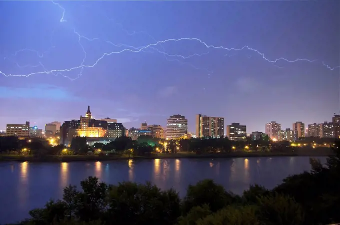 Lightening flashes over downtown Saskatoon during a summer thunderstorm; Saskatoon, Saskatchewan, Canada