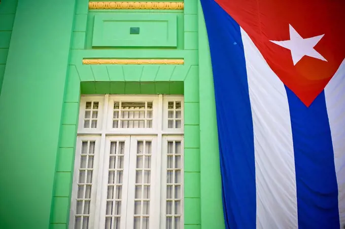 A Cuban flag hanging on a wall outdoors