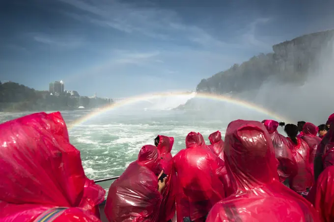 Tourists on a boat wearing red ponchos and viewing Niagara Falls; Niagara Fall, Ontario, Canada