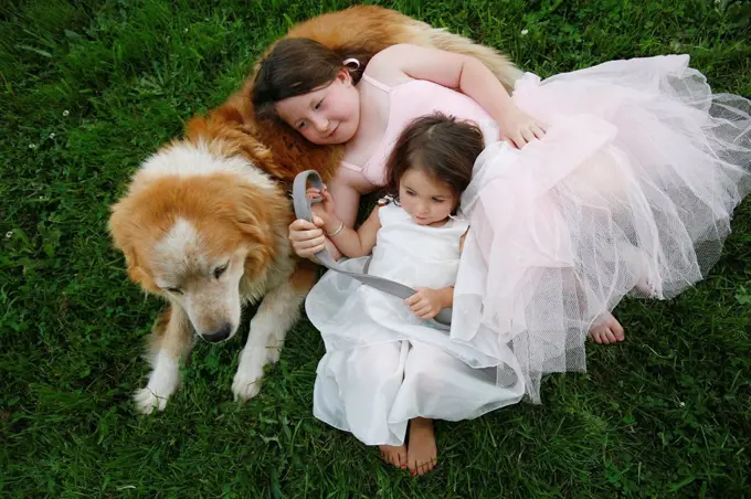 two sisters in dresses with their rescue dog outdoors, duncan, vancouver island, british columbia, canada