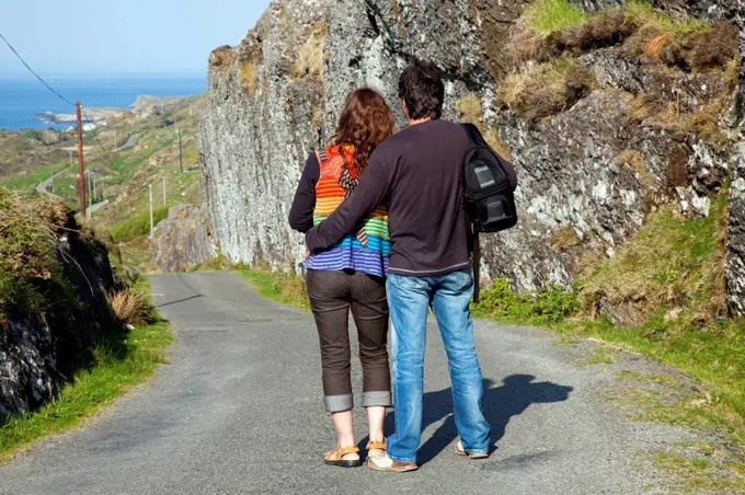 A Man And Woman Stand Looking At The View Of The Ocean Near Argroom, County Cork Ireland