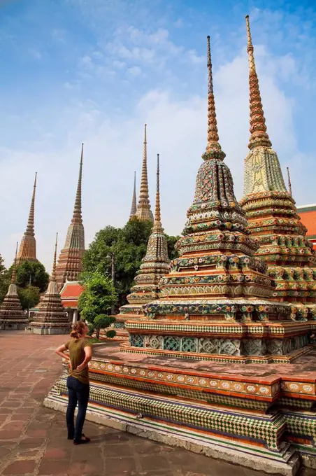 tourist viewing chedi at buddhist temple, bangkok, thailand