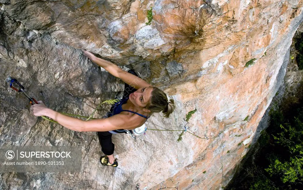 A climber makes her way up a steep and difficult route on the limestone cliffs in the Aveyron region, near Millau and Toulouse, south west France, Eur...