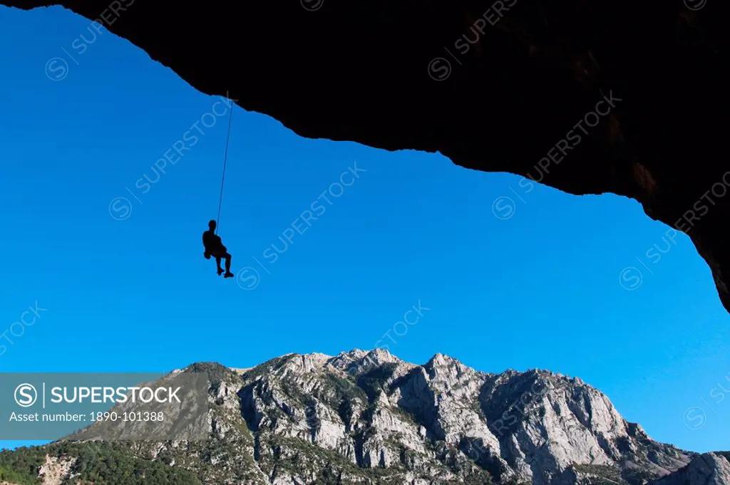 A climber lowers off a very overhanging cave climb on the cliffs above Bielsa, Spanish Pyrenees, Aragon, Spain