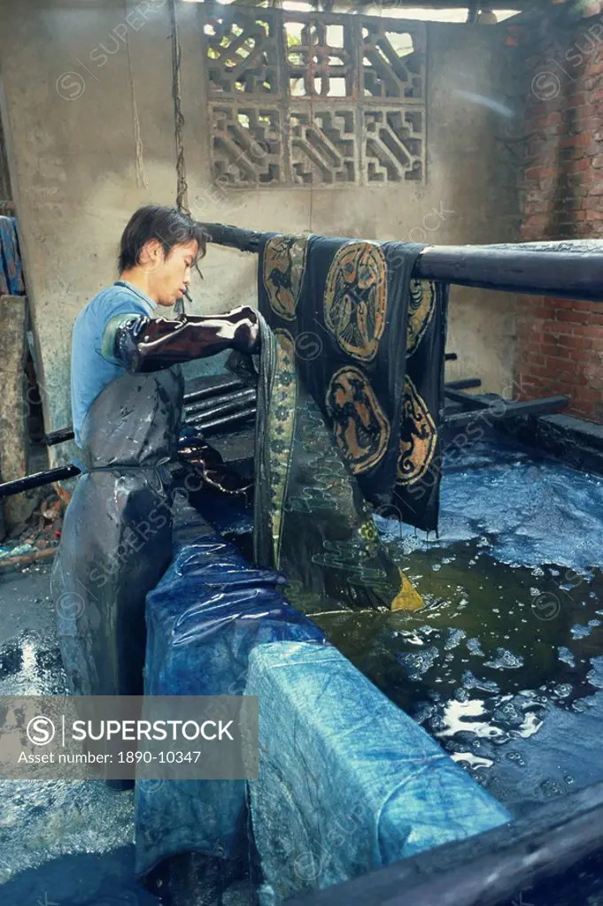 Dipping batik in an indigo vat, Guizhou, China, Asia