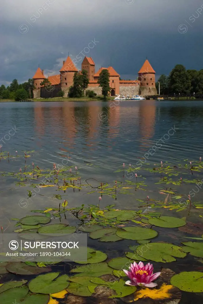 Castle Trakai, reflected in the water of a lake with a water lily, Trakai, Lithuania, Baltic States, Europe