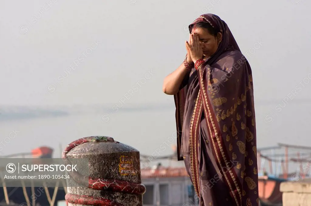 Woman praying in front of a lingam, Varanasi, Uttar Pradesh, India, Asia