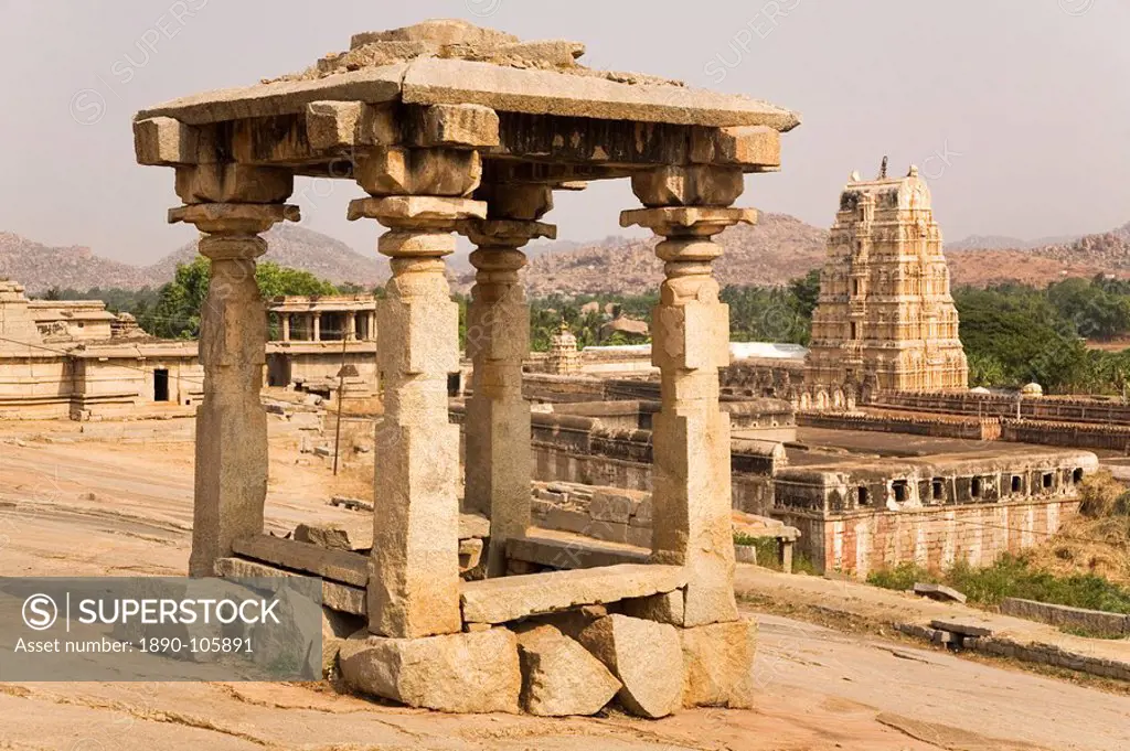 The 165 ft high Virupaksha Temple, sometimes know as the Pampapati Temple, is seen behind a simple four sided stome structure at Hampi, UNESCO World H...