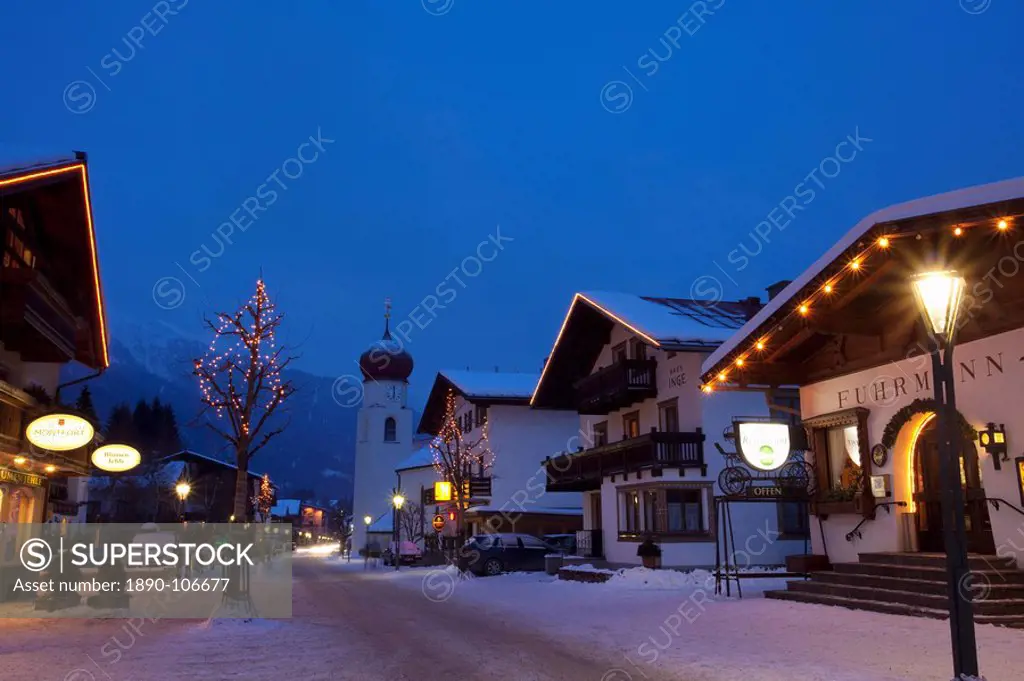 St. Anton am Arlberg main road and church in winter snow in the evening, Tyrol, Austrian Alps, Austria, Europe