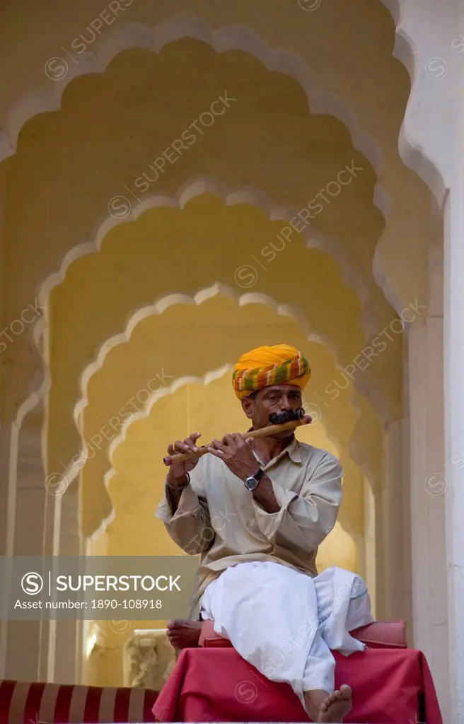 A man in traditional Indian dress playing a wooden flute at the Meherangarh Fort in Jodhpur, Rajasthan, India, Asia