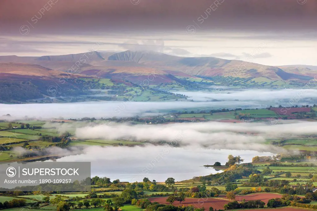 Pen Y Fan rises above a mist shrouded landscape near Llangorse Lake, Brecon Beacons National Park, Powys, Wales, United Kingdom, Europe