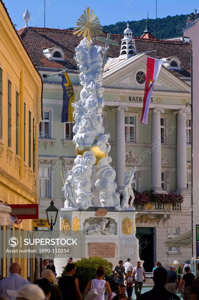The Trinity Column dating from 1714 and people walking around Hauptplatz surrounded by 18th century buildings, Baden, Austria, Europe