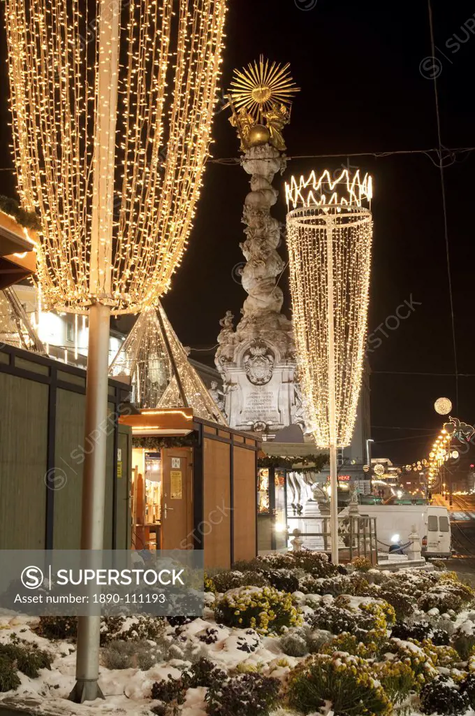 Snow_covered flowers, Christmas decorations and Baroque Trinity Column Dreifaltigkeitssaule at Christmas Market, Hauptplatz Square, Linz, Oberosterrei...