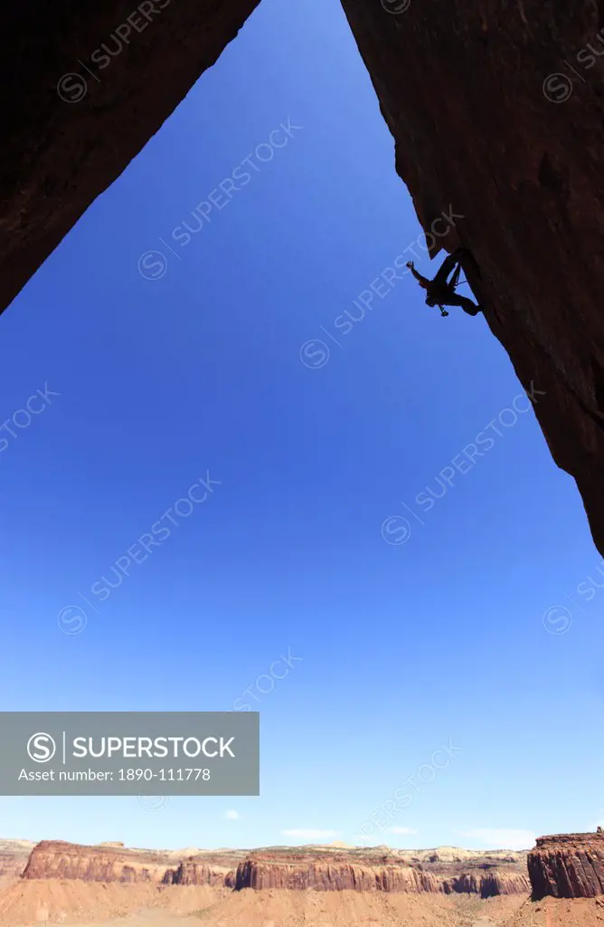 A rock climber tackles an overhanging wall on the cliffs of Indian Creek, a famous rock climbing area near Moab, south eastern Utah, United States of ...
