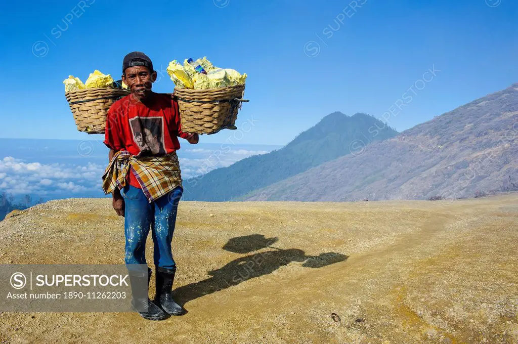 Worker carrying big pieces of sulphur out of the Ijen Volcano, Java, Indonesia, Southeast Asia, Asia