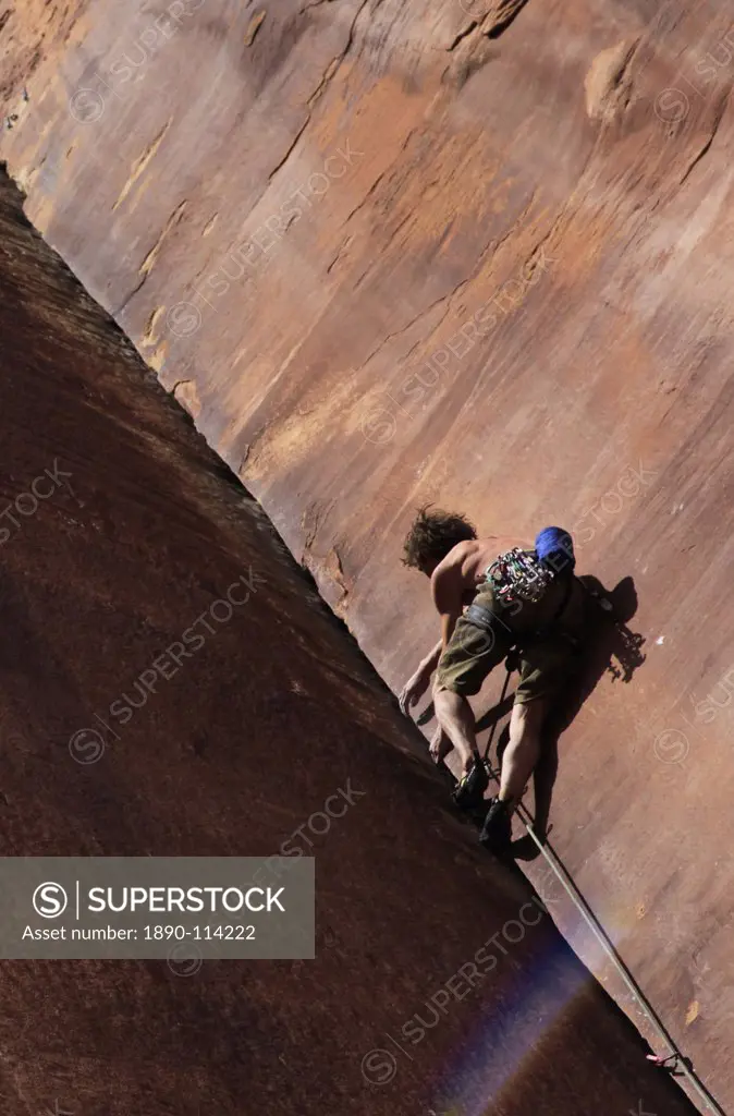 A climber tackles an overhanging corner on the cliffs of Indian Creek, a famous rock climbing area near Moab, Utah, United States of America, North Am...
