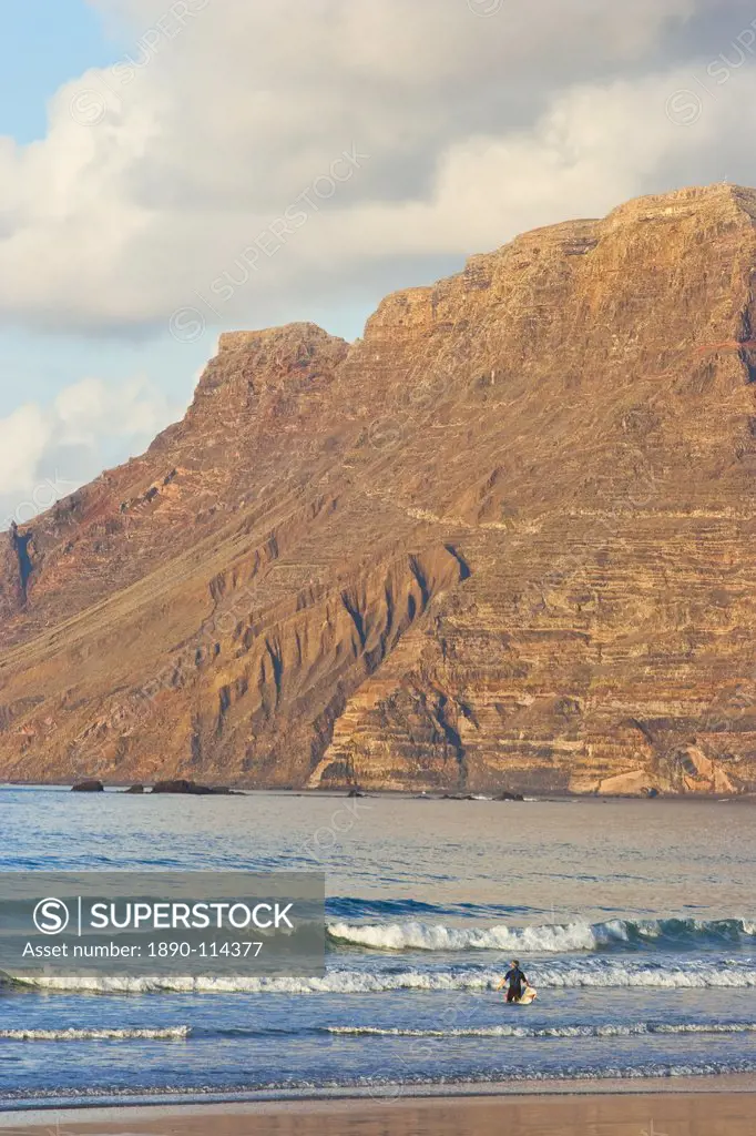 Spectacular 600m volcanic cliffs of the Risco de Famara rising over Lanzarote´s finest surf beach at Famara in the north west of the island, Famara, L...