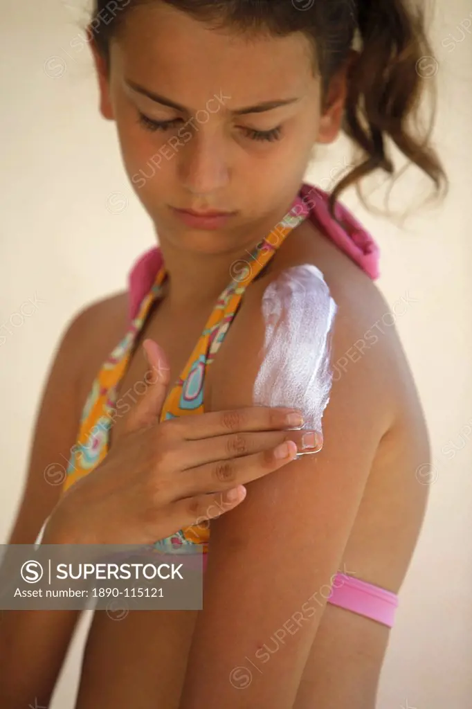 Girl putting on sunblock, Italy, Europe