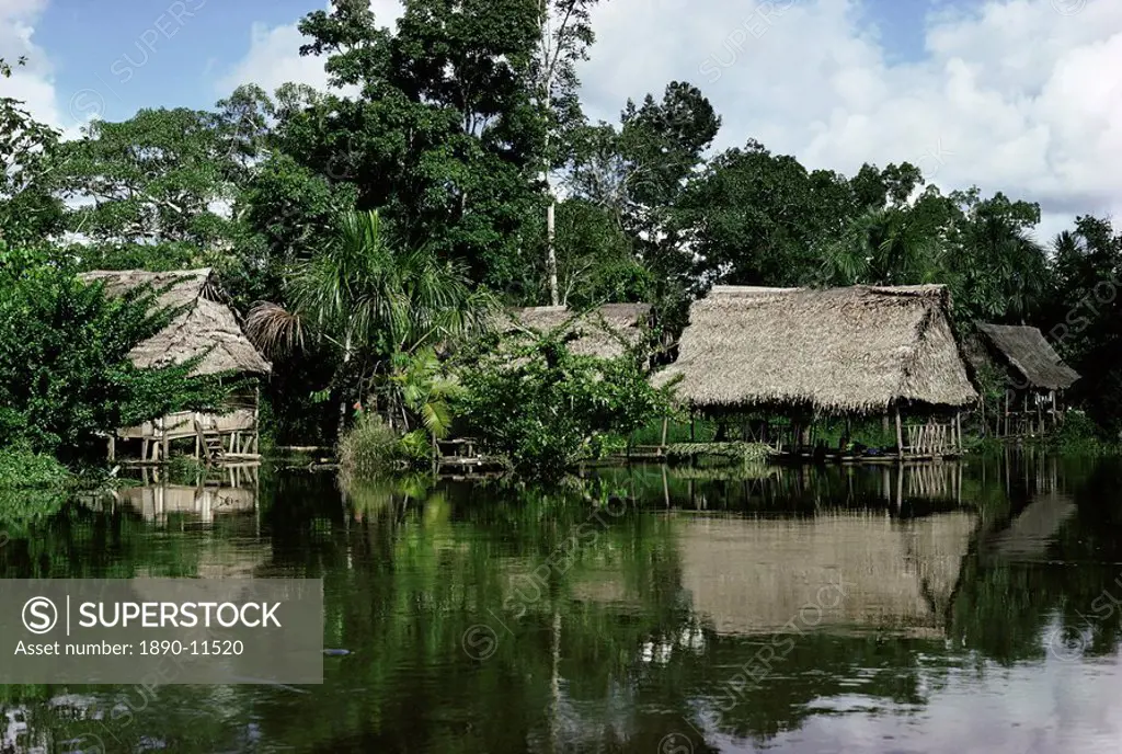 Building on stilts reflected in the River Amazon, Peru, South America