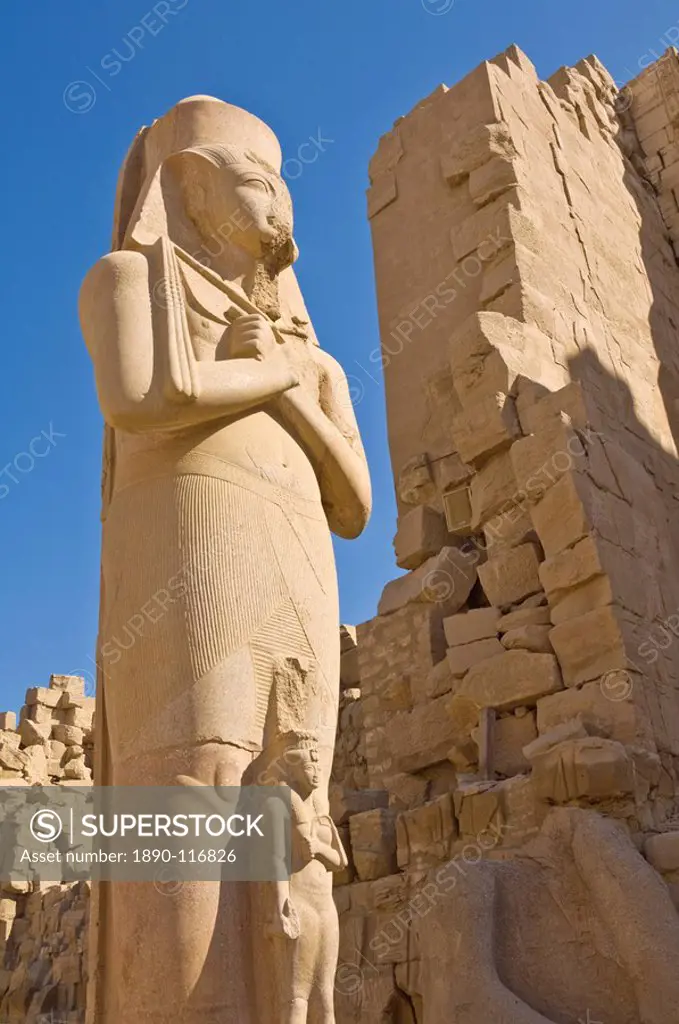 Giant statue of the great pharaoh Rameses II with the small statue of his daughter Bent´anta between his legs in the forecourt behind the first Pylon ...