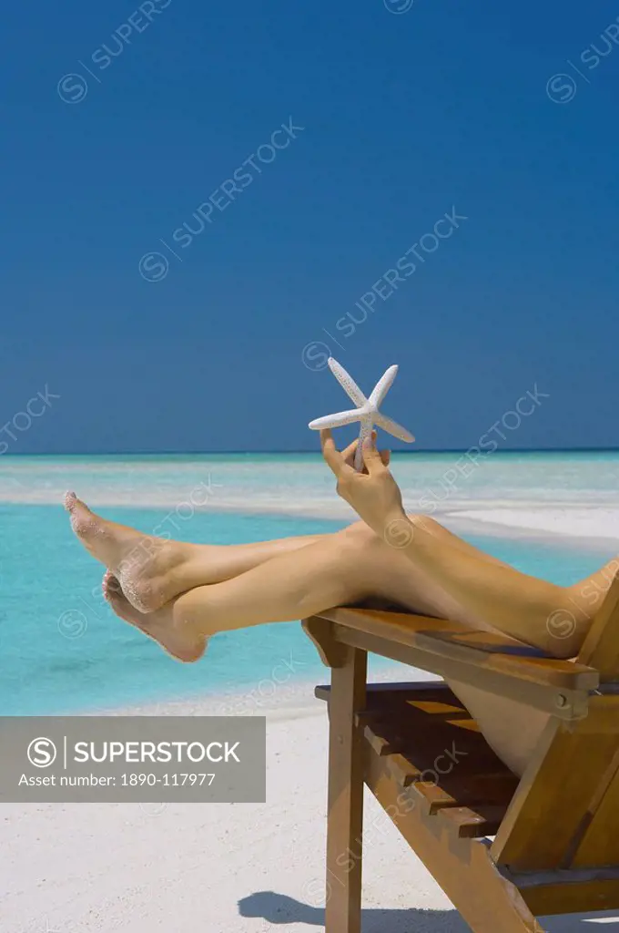 Woman holding seastar on the beach, Maldives, Indian Ocean, Asia